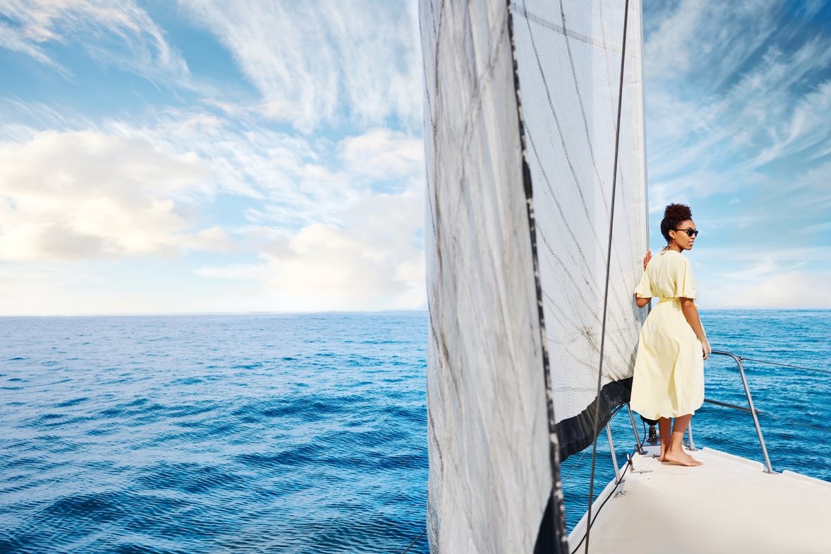 Shot of a young woman enjoying a relaxing day on a yacht