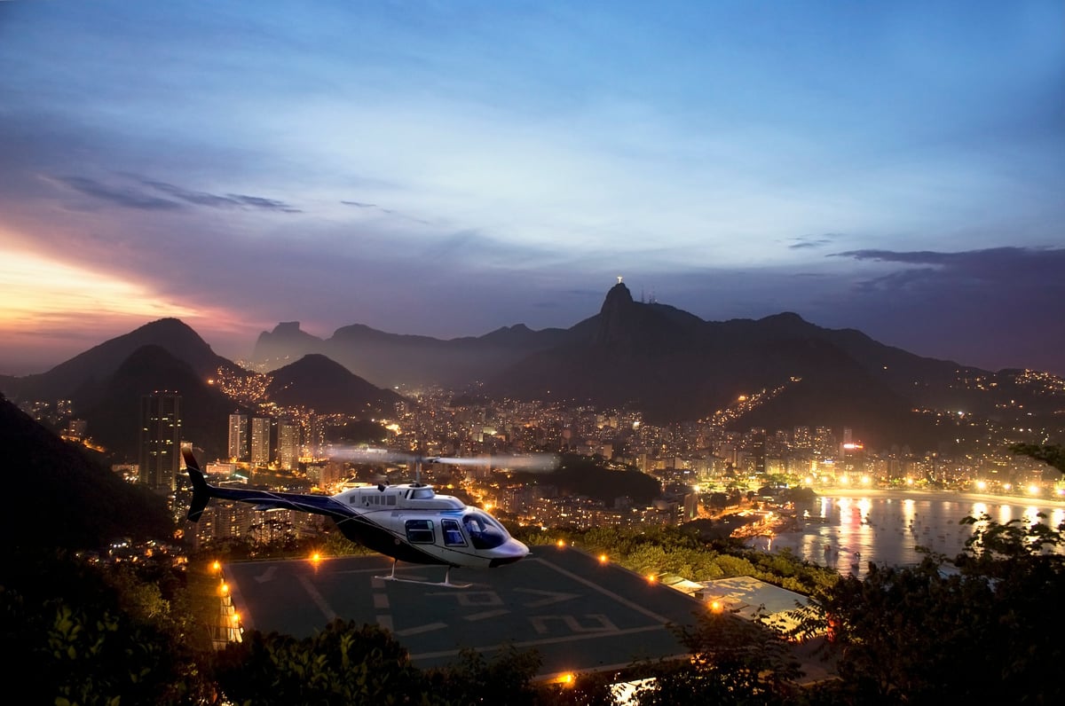 Panoramic view of Rio de Janeiro from sugar-loaf mountain with helicopter pad and helicopter taking off