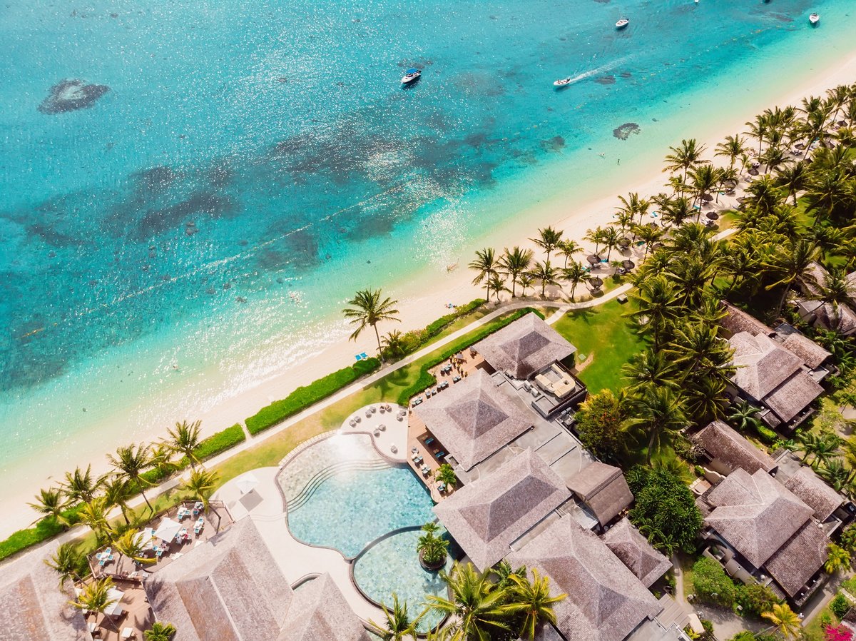 Luxury beach with hotel in Mauritius. Sandy beach with palms and blue ocean. Aerial view