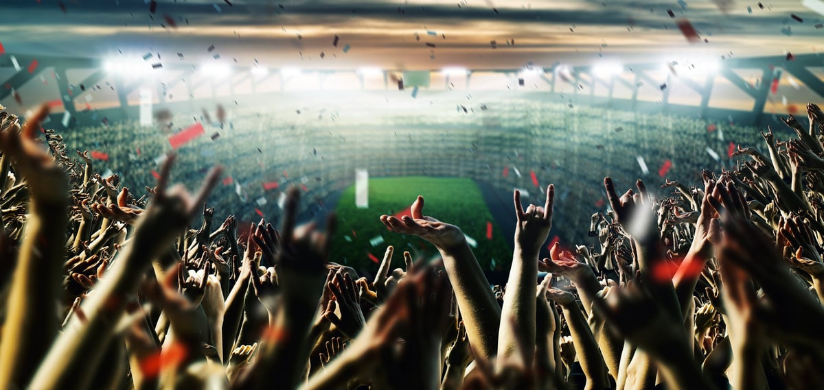 Electric stadium crowd atmosphere with dramatic lighting and celebration at a major live event