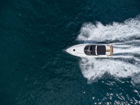 Aerial top down view of speed motor boat on open blue sea