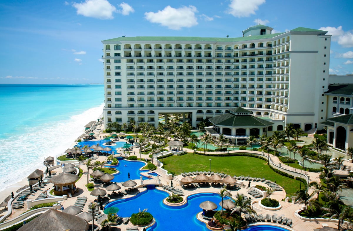 Aerial view of a luxury resort with pools and oceanfront