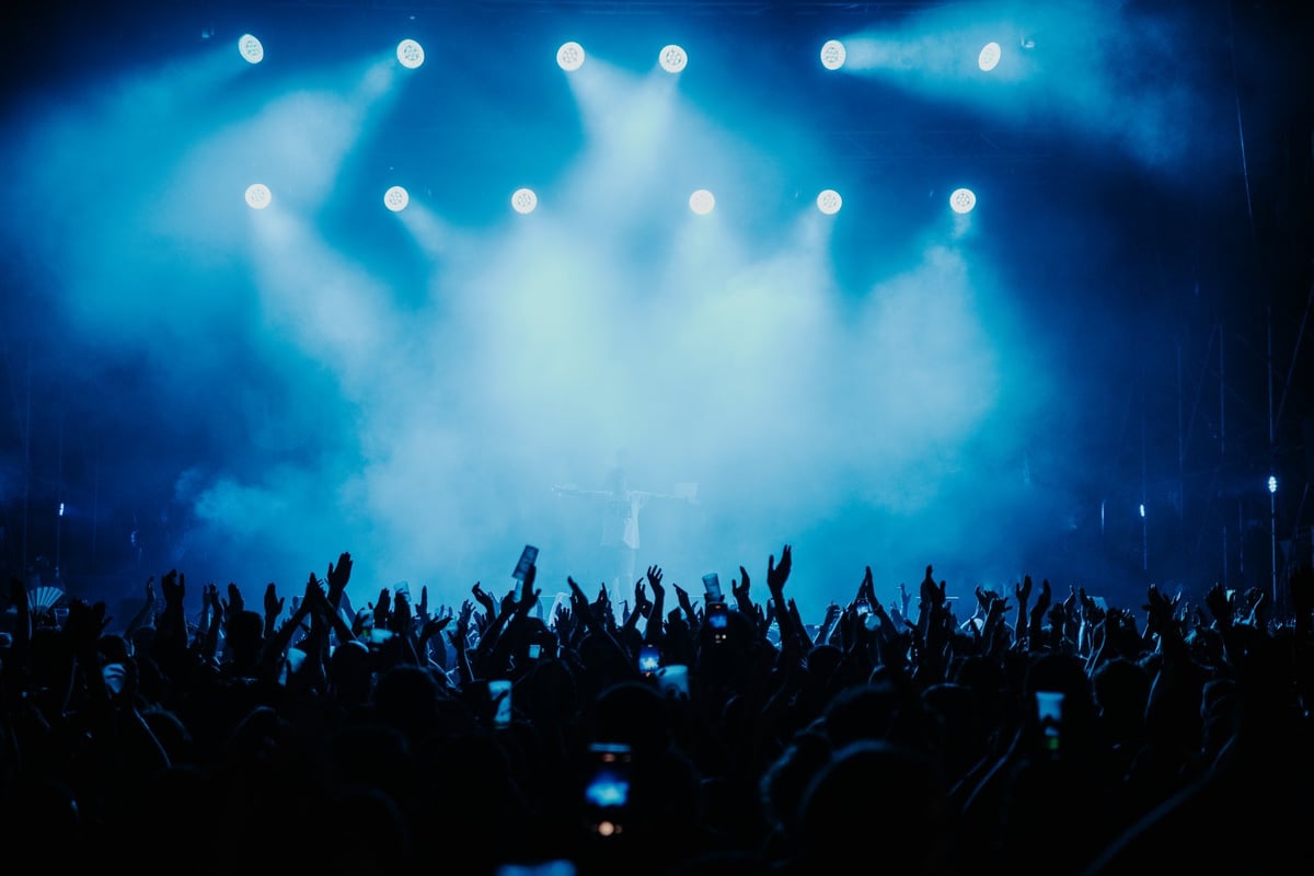 Crowd of people dancing at a music show in Barcelona in blue colour