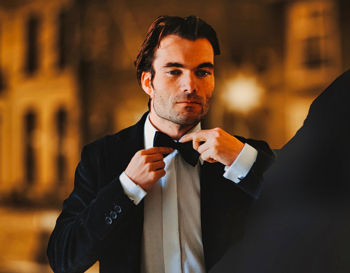 Man preparing tuxedo bow tie for evening awards ceremony function
