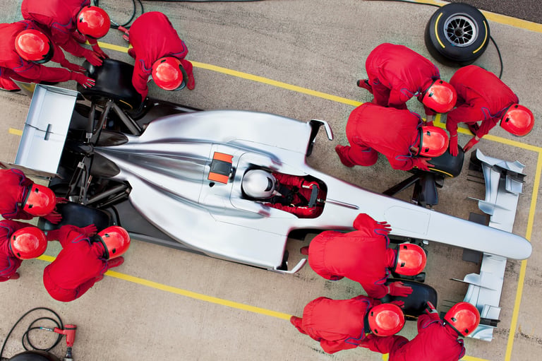 Formula 1 pit stop crew working on race car overhead view