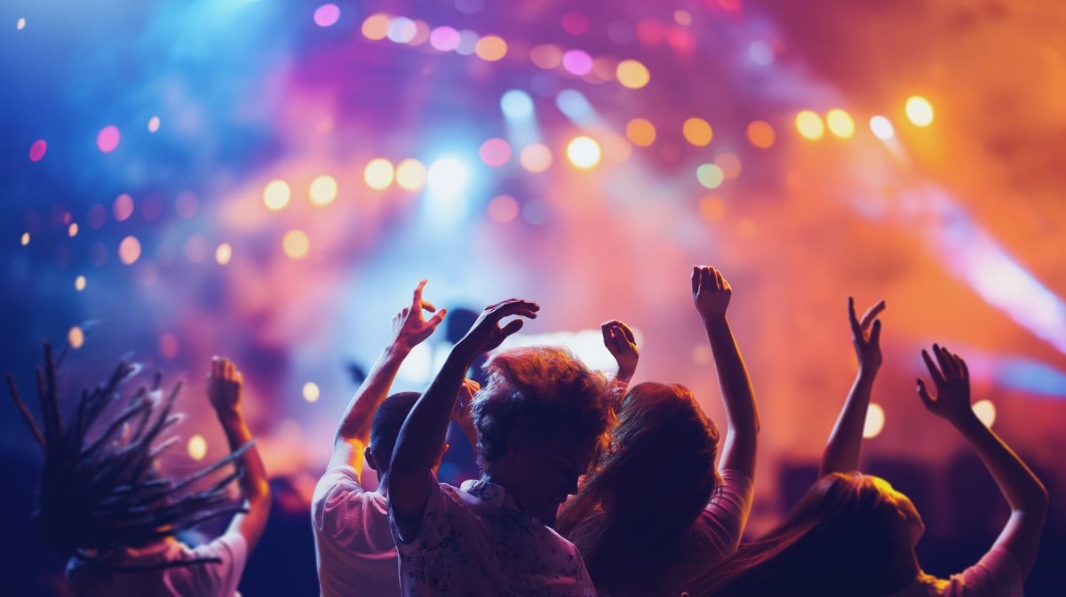 Overjoyed happy young people dancing and singing during concert