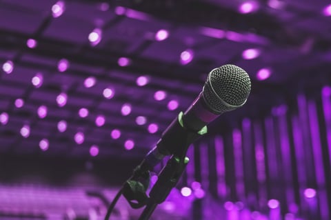 Microphone on the theater stage before the concert with purple blurred lights