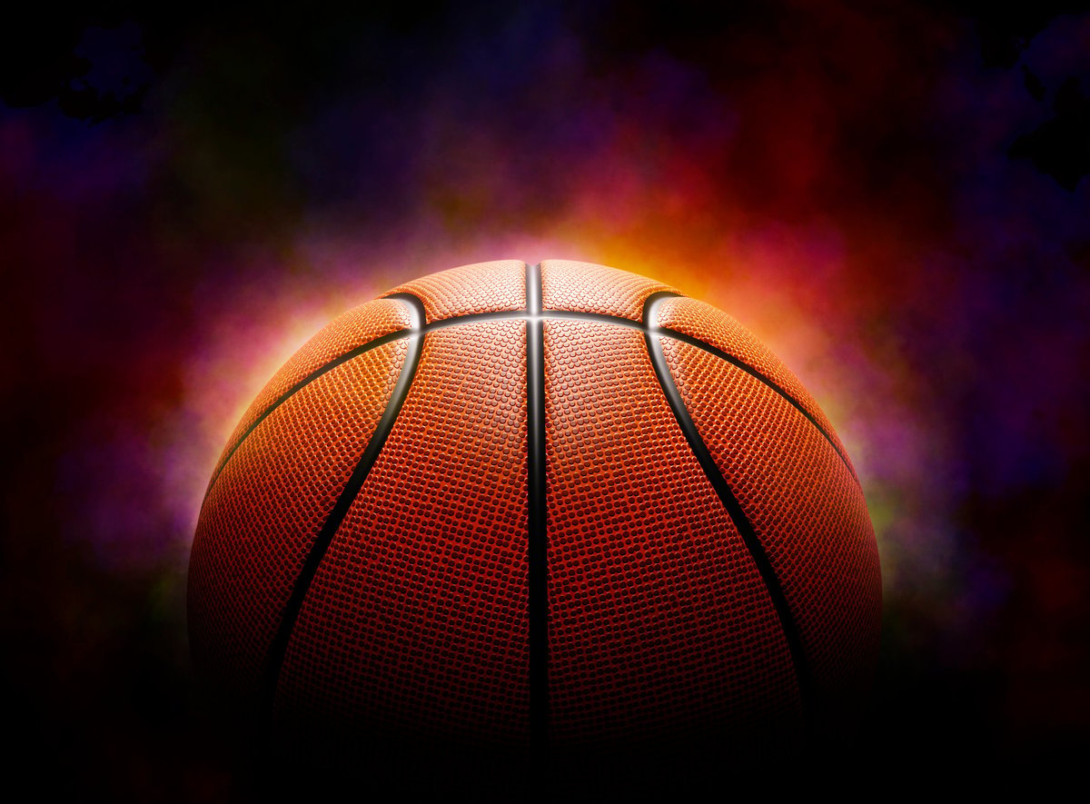 Basketball on dramatic color smoke background representing championship atmosphere