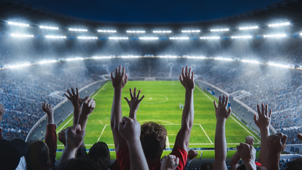 High angle shot of fans cheering for team on a big stadium during championship match