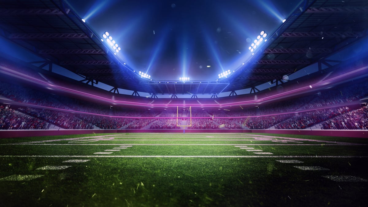 Aerial view of American football stadium with illuminated arena and fans