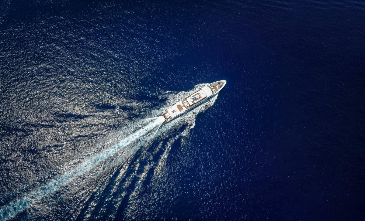 Luxury yacht cruising at high speed over blue ocean