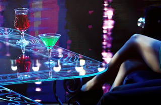 Close-up of cocktails on glass table in dim atmosphere
