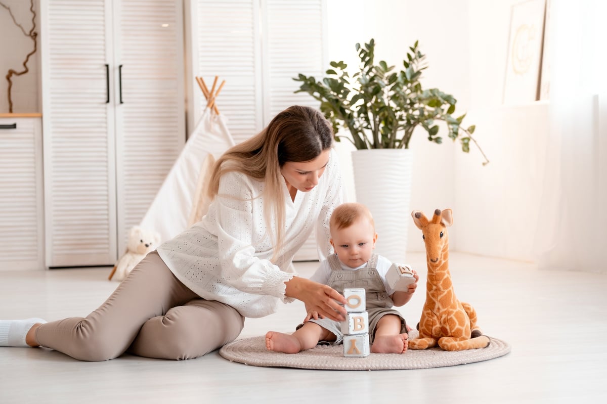 Young mother playing with child at home