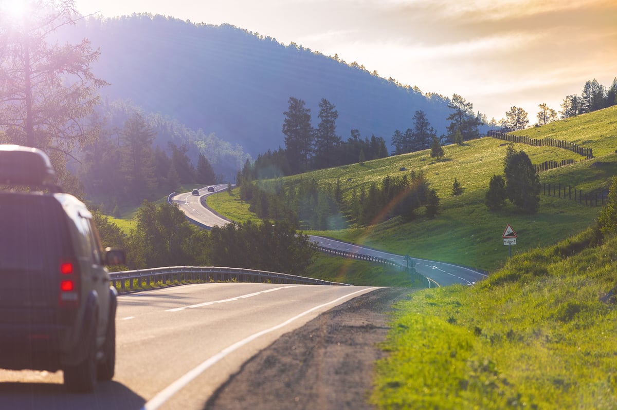 Sunny mountain landscape with winding asphalt road