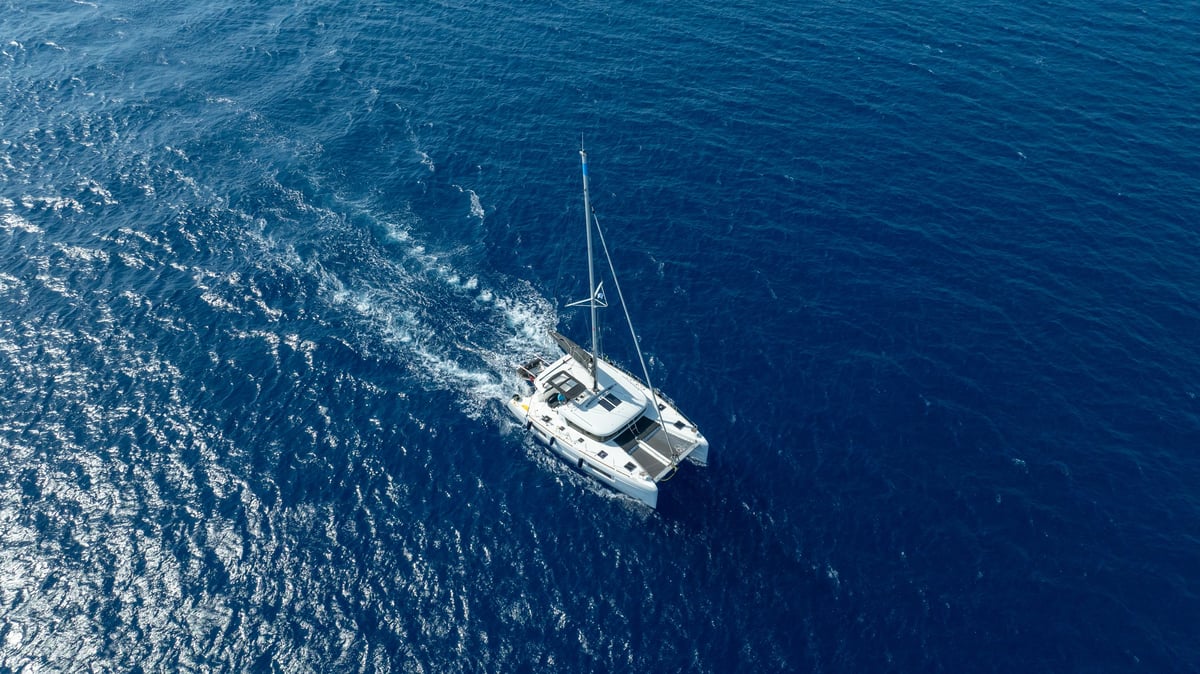 A sleek catamaran sailing across the clear blue waters on the open sea