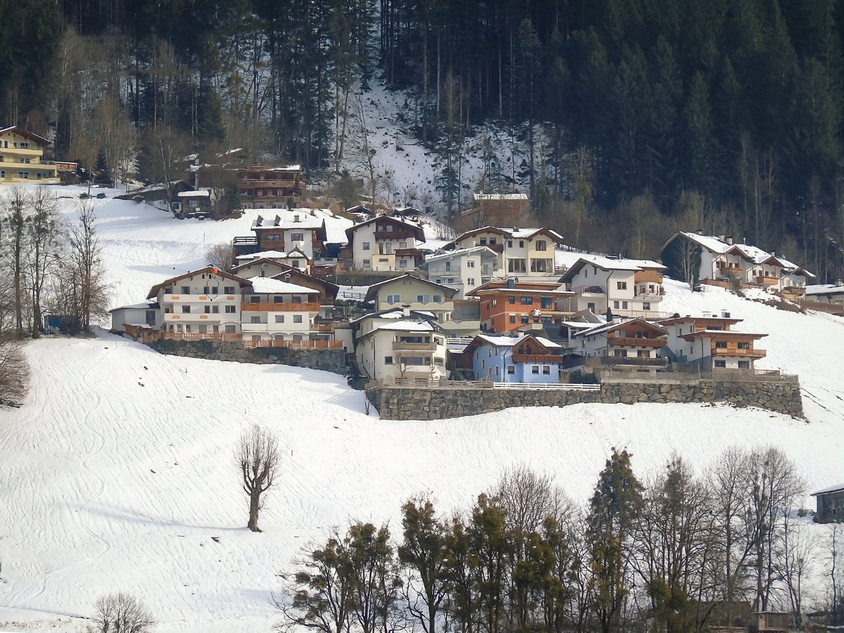 A picturesque view of various buildings of a winter ski resort located on a snowy mountain slope