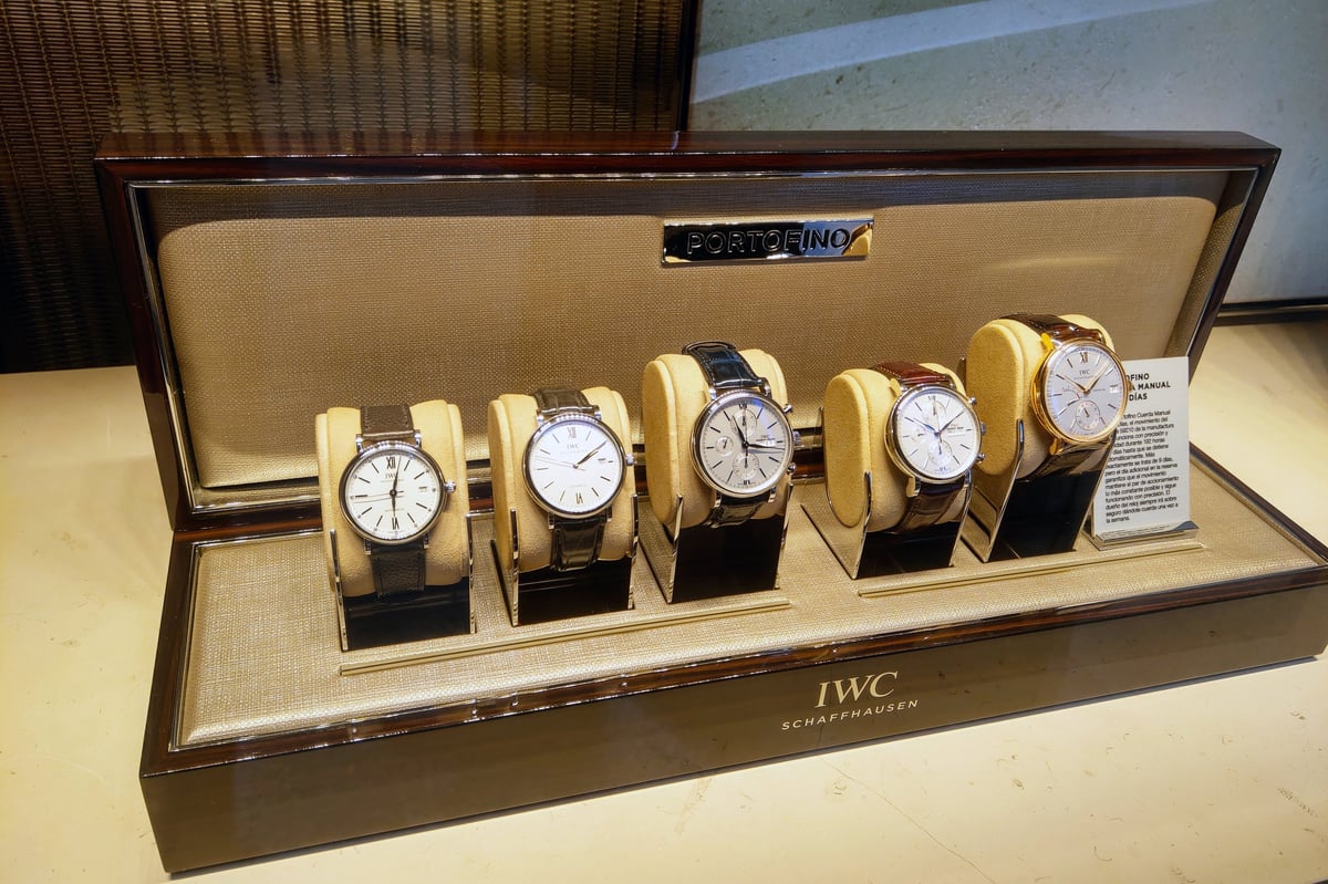 Showcase of five IWC Portofino watches elegantly displayed in a retail case, crafted with precision and style, luxury watchmaking artistry from IWC Schaffhausen