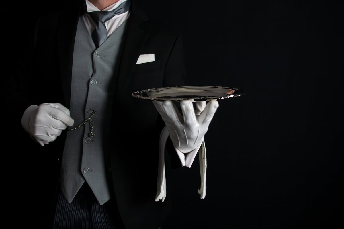 Butler holding tray, luxury hotel service and tipping etiquette