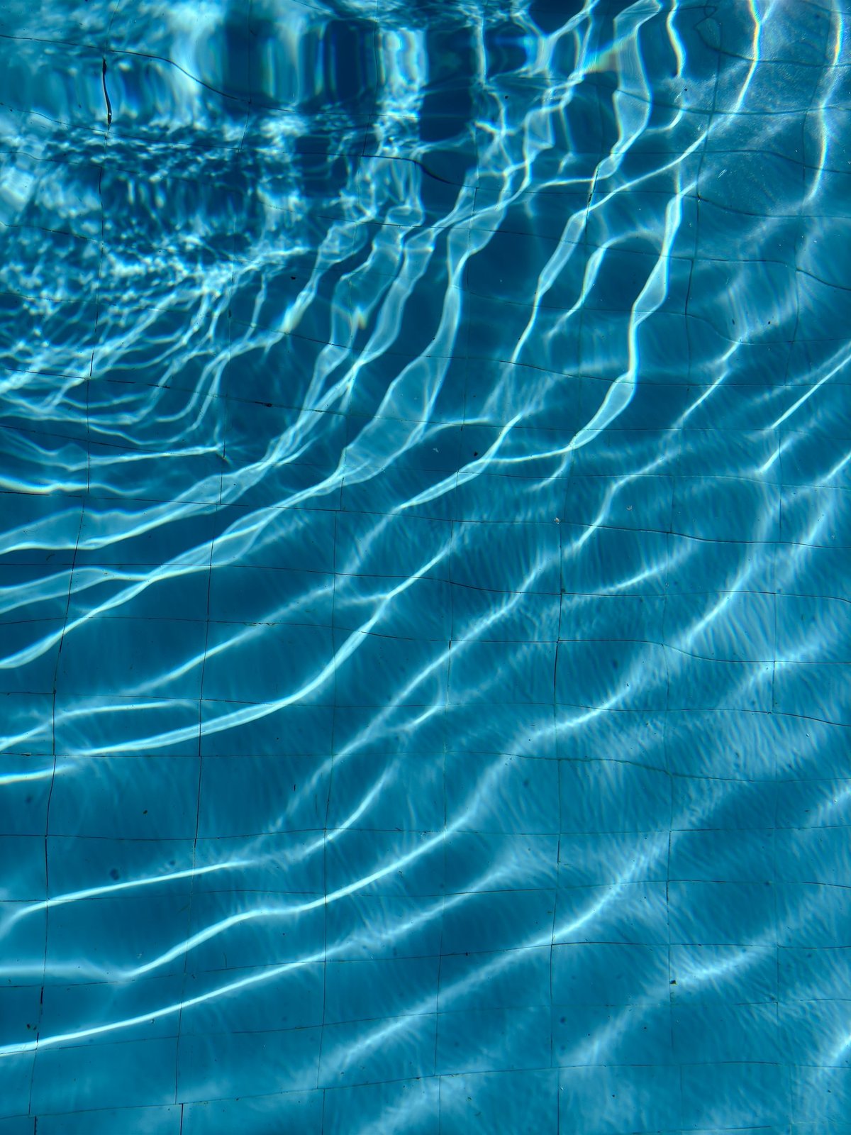 A body of water with blue waves and ripples, serene and tranquil atmosphere
