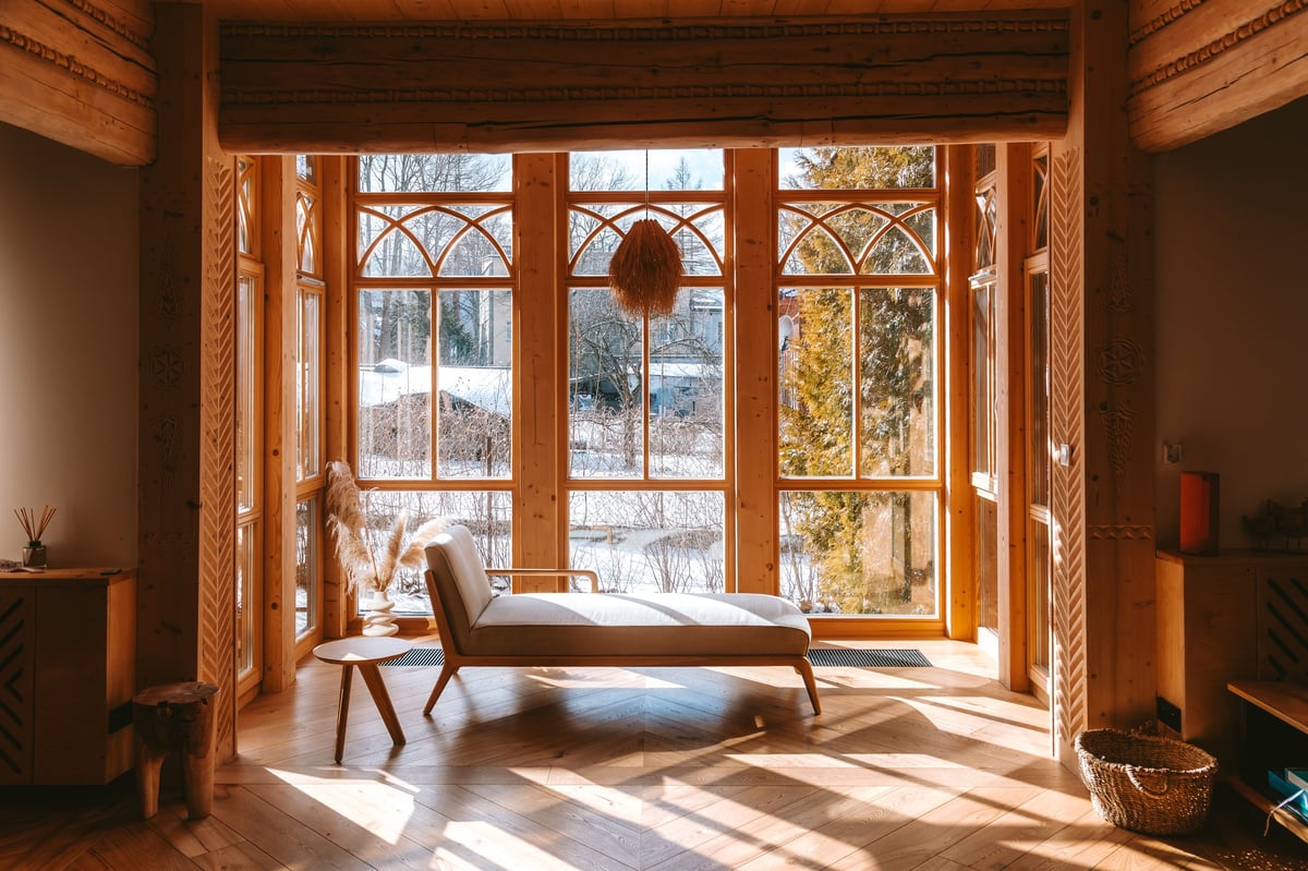 Sunlight streaming through large windows of a cozy wooden chalet