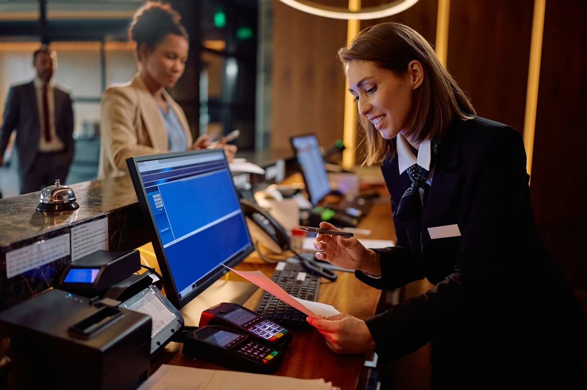 Hotel manager at reception desk providing VIP concierge service