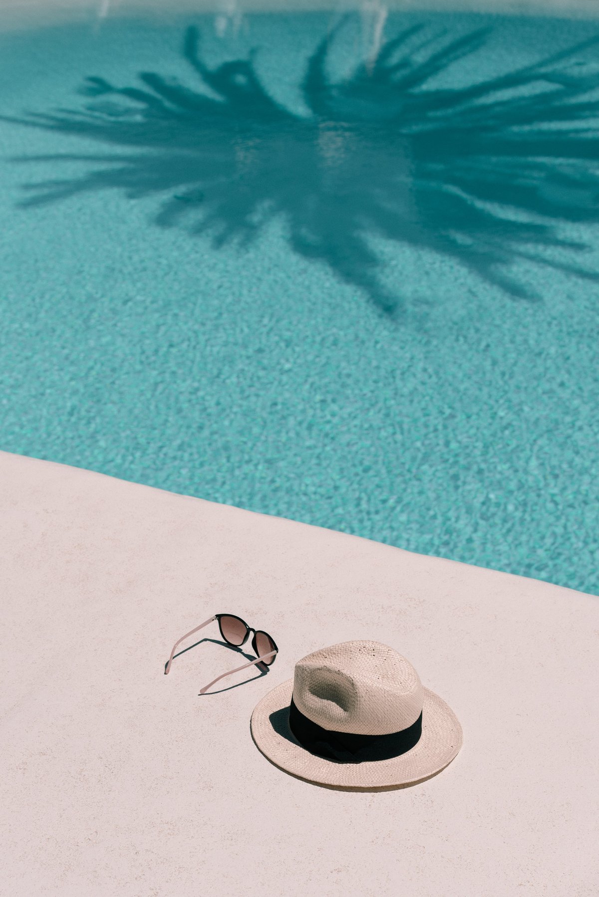 Straw hat sunglasses at poolside summer vacation holidays