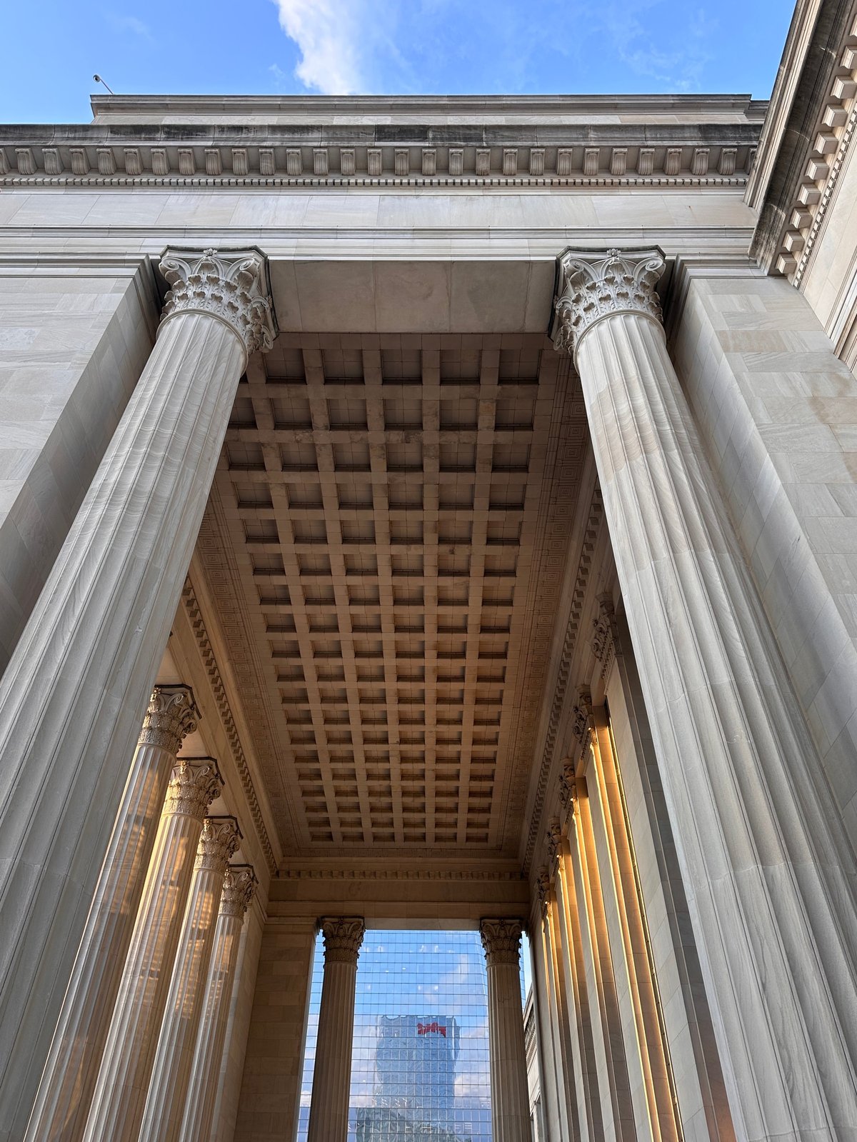 The full entryway of 30th Street Station framed with columns and glowing light