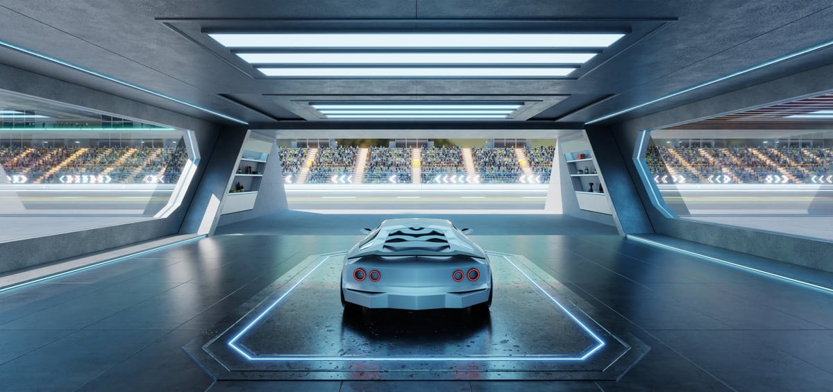 Racing car in futuristic garage overlooking racetrack