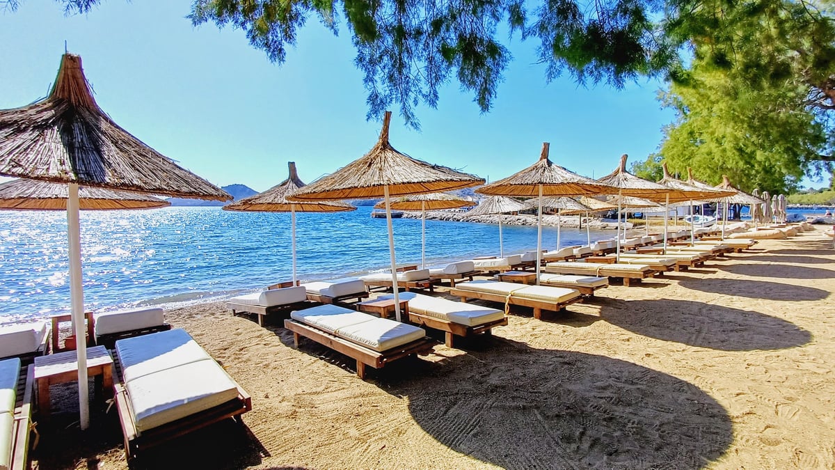 Beach holiday seaside with sun loungers and umbrellas
