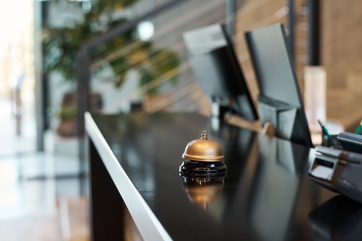 Gold bell on modern hotel reception desk reflecting ambient light