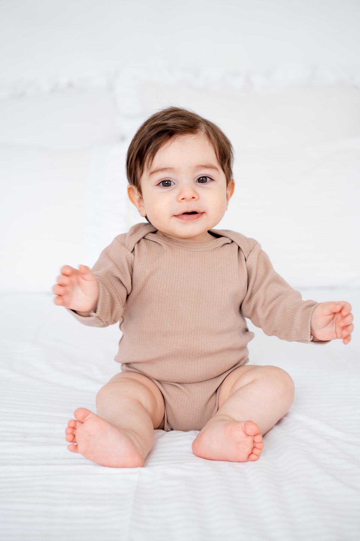 Smiling baby boy on the bed at home