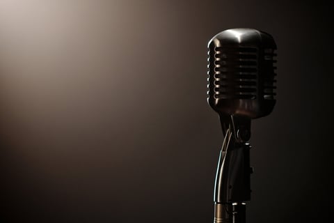 Vintage microphone standing on stage with dramatic lighting