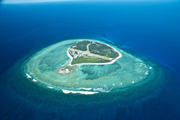 Private tropical island aerial view with crystal clear turquoise waters
