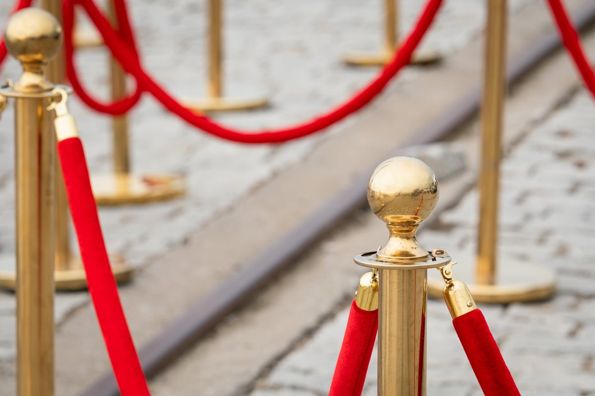 Golden stanchions with red velvet ropes at a VIP event