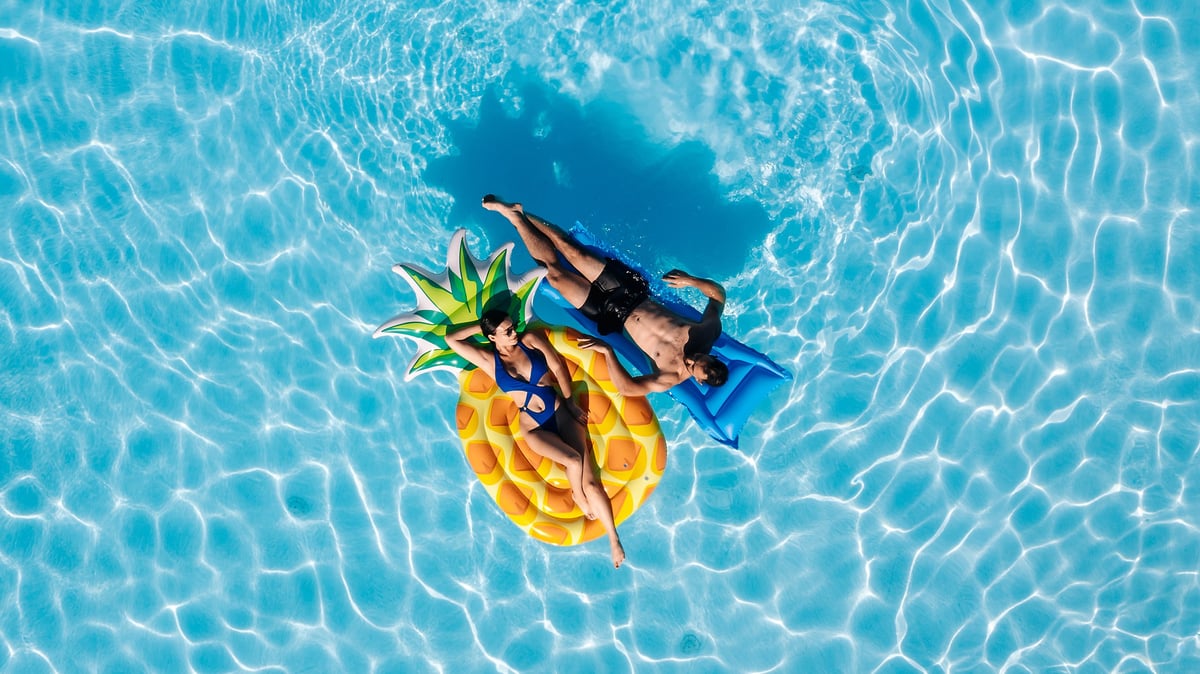 Young beautiful couple relaxing and enjoying vacation in the pool