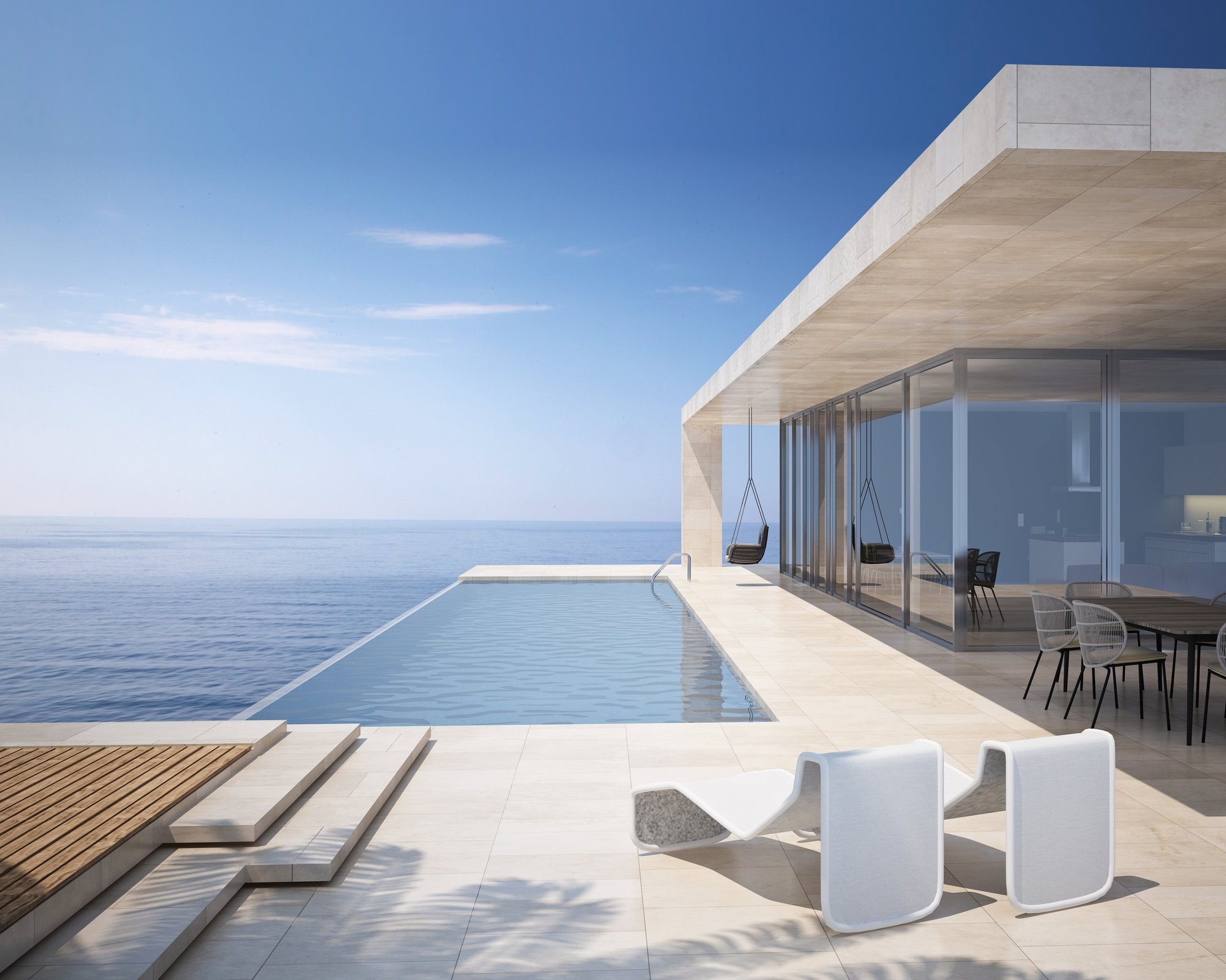 Modern luxury villa with infinity pool overlooking the ocean at sunset