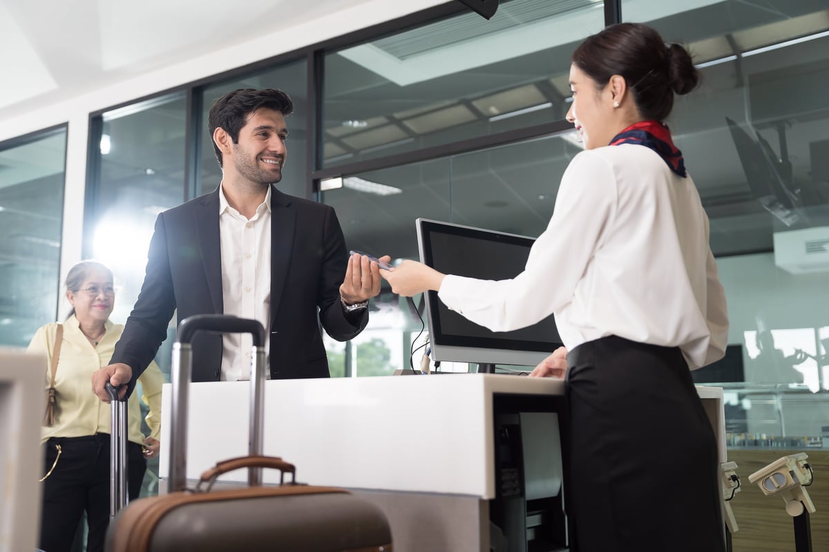 Airport and passenger concept woman airline ground staff helping traveler