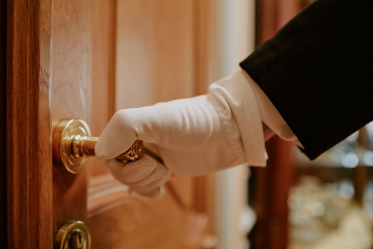 Professional butler in white gloves