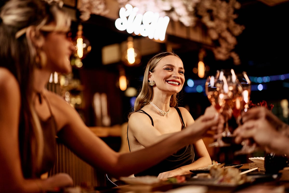 Women enjoying a celebratory toast with drinks in a stylish and vibrant atmosphere