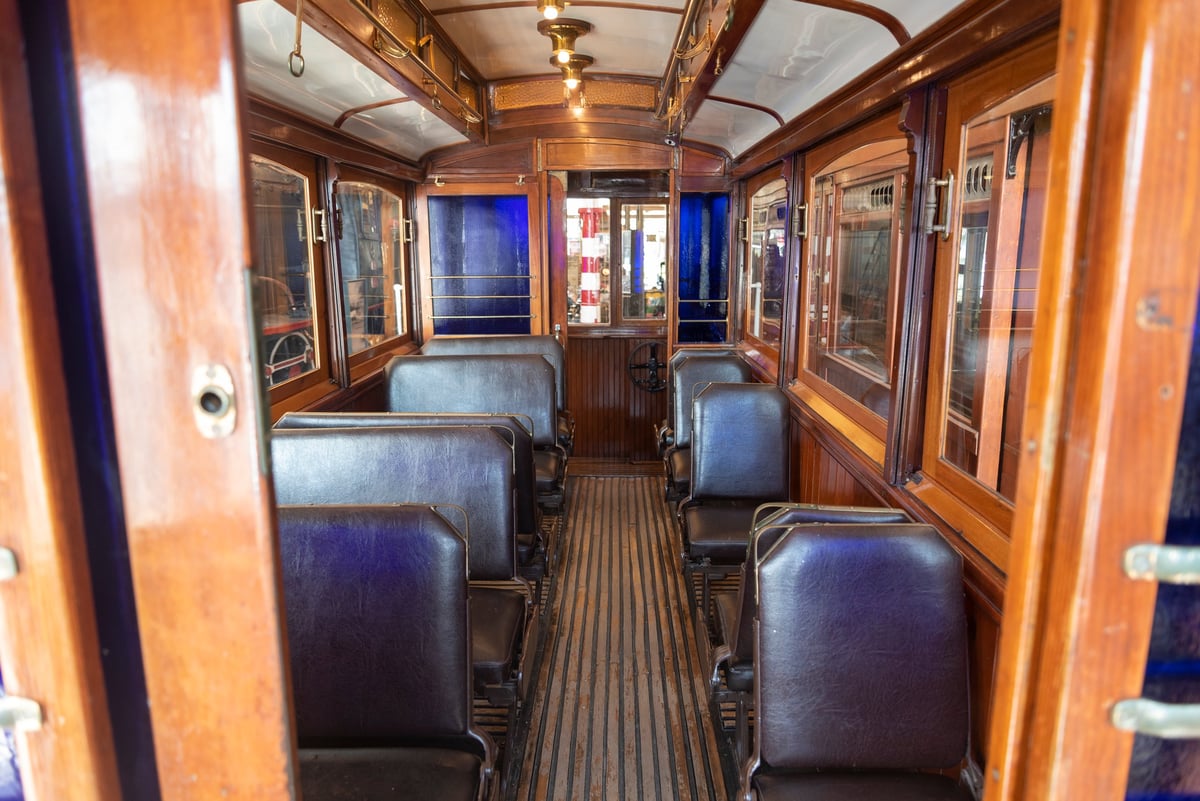 Wooden panels and vintage seating create an inviting atmosphere inside this historical train carriage