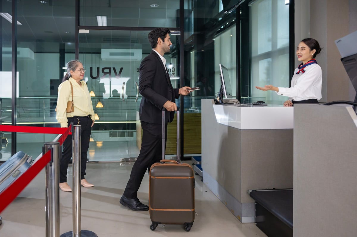 Caucasian businessman passenger receiving boarding pass from airline ground crew