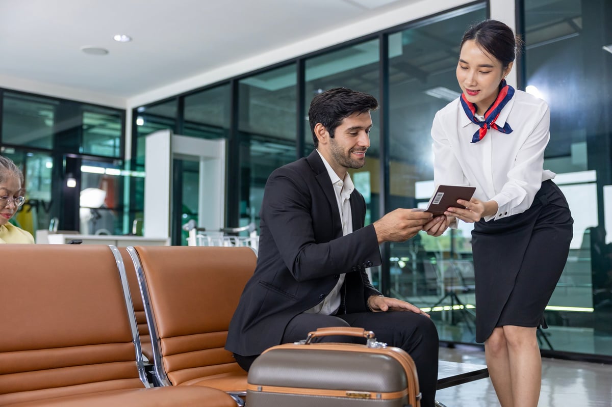 Businessman passenger showing boarding pass to airline ground crew