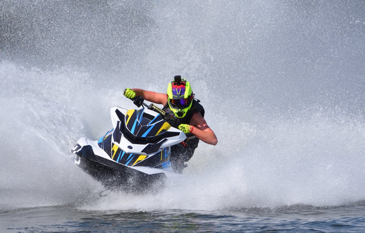 Jet Ski racer cornering at speed creating a lot of spray