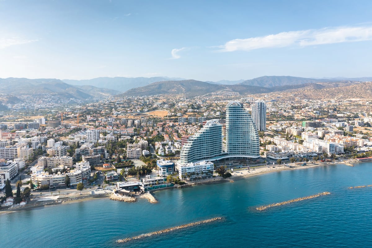 Breathtaking panoramic view of modern coastal city with mountains in background