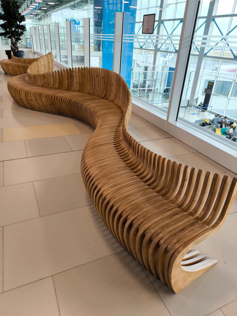 Modern luxury airport terminal with curved wooden bench and bright open waiting area