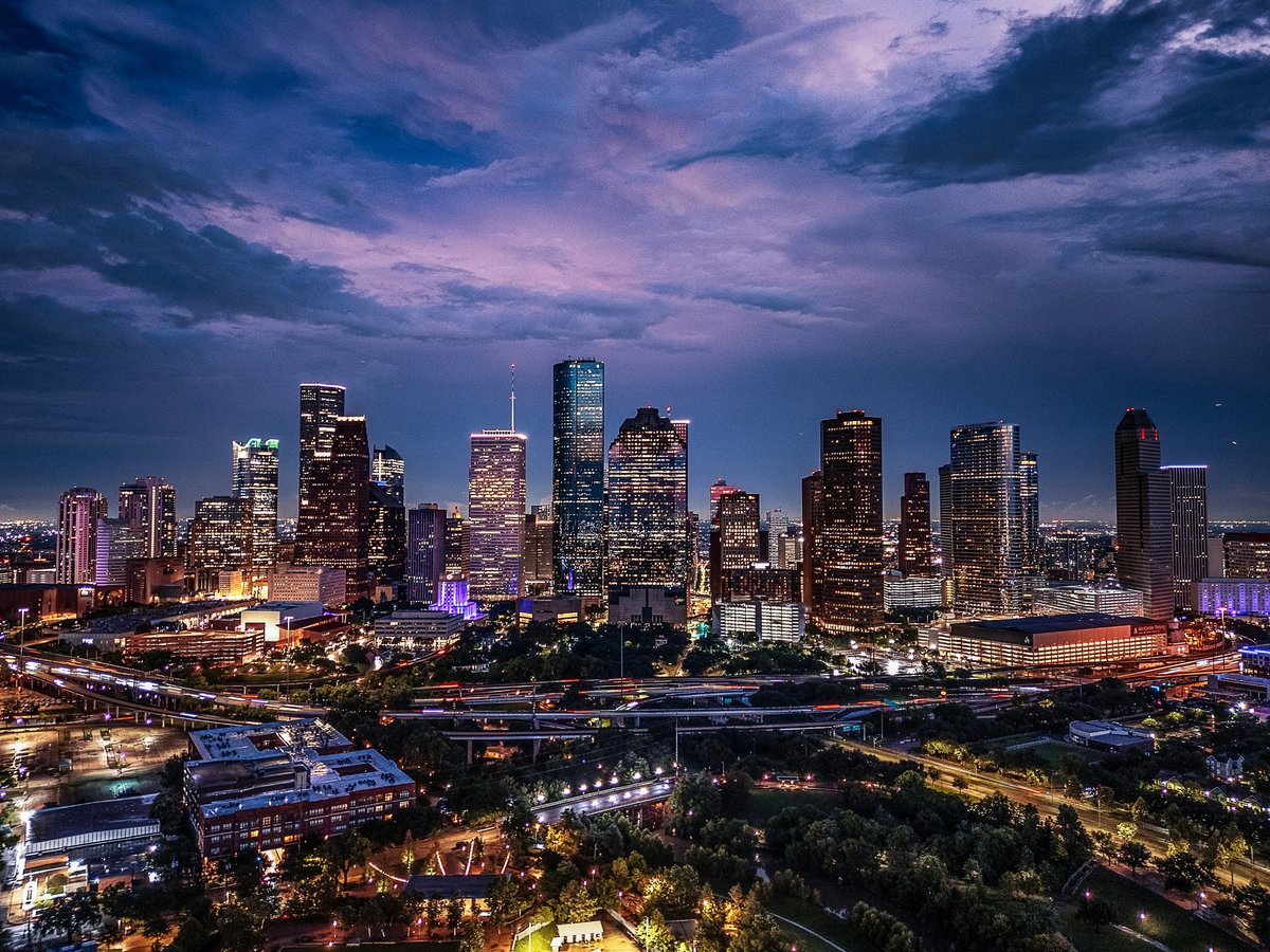 Drone aerial image of downtown skyline captured at twilight with illuminated skyscrapers