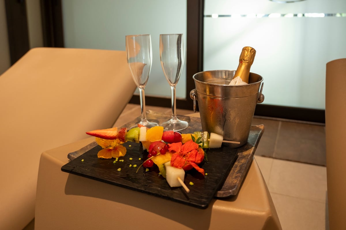 A tray of fruit and champagne on a table