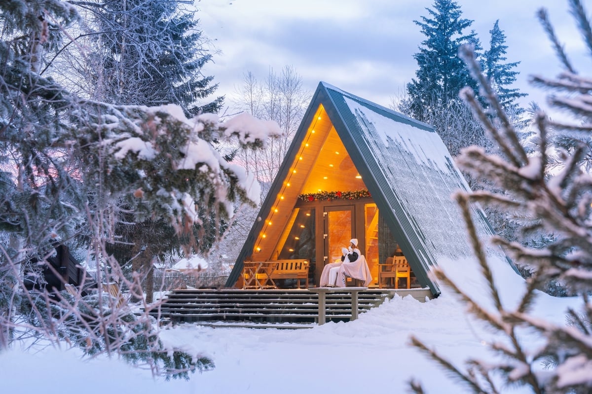 A-frame cabin in serene winter forest with mountain views