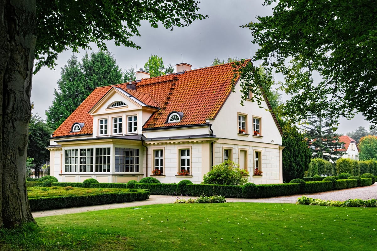 Beautiful tradition wealthy suburban house among green summer garden