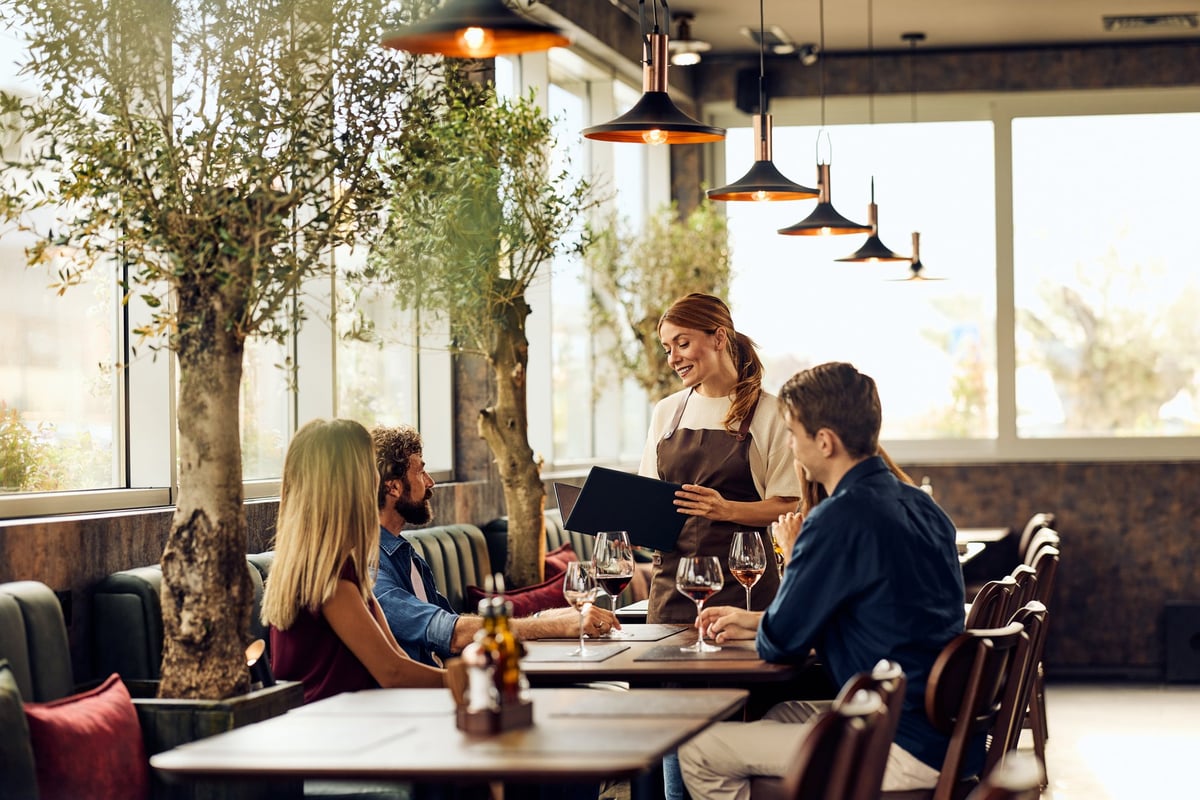 Diners enjoy a cozy meal with professional waitress service in a trendy restaurant